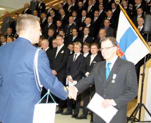 Reserviläispiirin pj Jouko Hyppönen vastaanottaa ev Pasi Hakalalta Reserviläisliiton kultaisen ansiomitalin.
